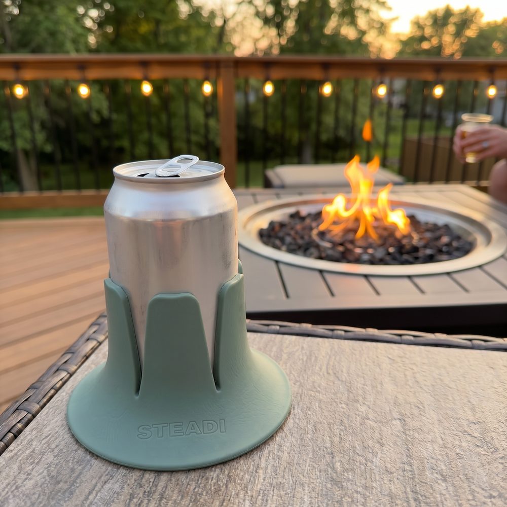A can standing in a sage Steadi on an outdoor table at dusk.